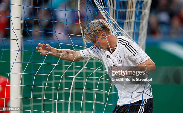 Sebastian Polter of Germany hangs in the net after scoring his team's third goal during the Under 21-Euro qualifier match between Germany U21 and...