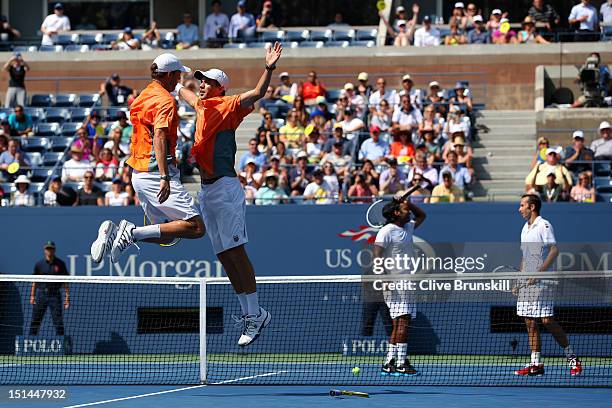 Bob Bryan and Mike Bryan of the United States celebrate match point with a chest bump as Leander Paes of India and Radek Stepanek of the Czech...