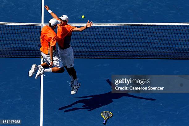 Bob Bryan and Mike Bryan of the United States celebrate match point with a chest bump as Leander Paes of India and Radek Stepanek of the Czech...