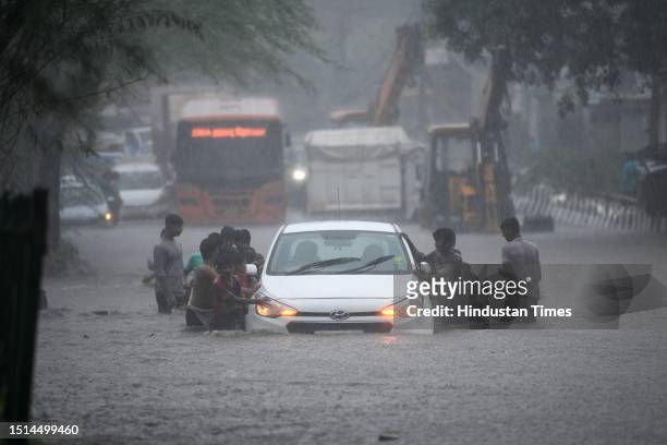 Commuters seen moving through water logged streets after heavy rainfall at Rohtak Road on July 8, 2023 in New Delhi, India. Delhi-NCR was drenched...