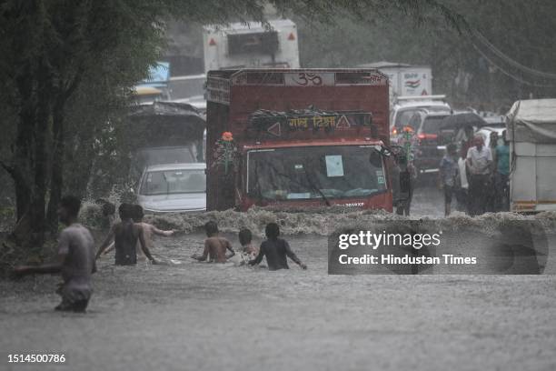 Commuters seen moving through water logged streets after heavy rainfall at Rohtak Road on July 8, 2023 in New Delhi, India. Delhi-NCR was drenched...
