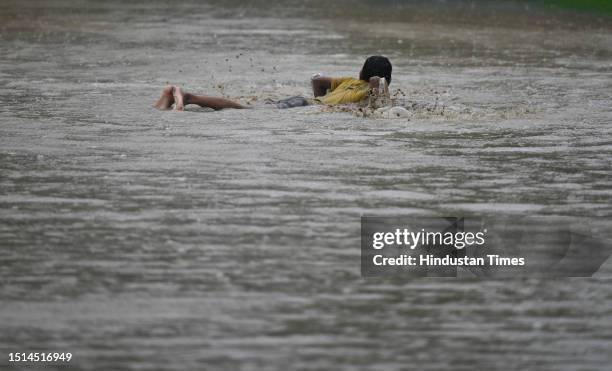 Child seen playing in water logged street after heavy rains at Sector 31, on July 8, 2023 in Noida, India. Delhi-NCR was drenched with heavy rain on...