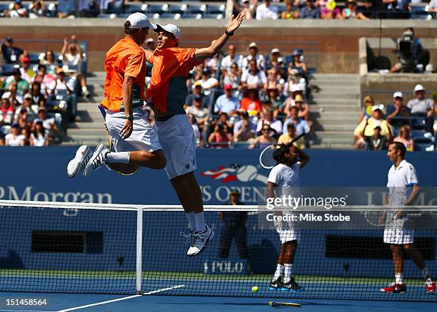 Bob Bryan and Mike Bryan of the United States celebrate match point with a chest bump as Leander Paes of India and Radek Stepanek of the Czech...