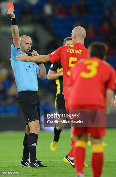Referee Stefan Johannesson of Sweden shows the red card to James Collins of Wales during the FIFA 2014 World Cup Group A Qualifier between Wales and...