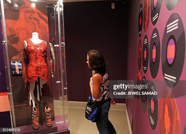 Visitor looks at the raw meat dress worn by Lady Gaga at a 2010 awards ceremony during "Women Who Rock; Vision, Passion, Power" exhibition at the...