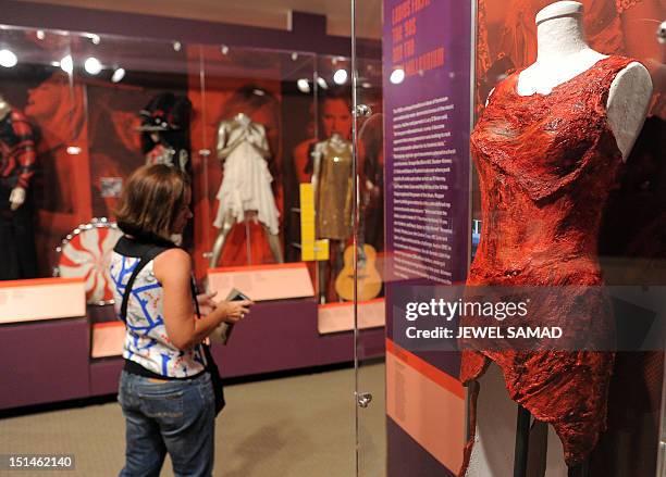 Visitor looks at the raw meat dress worn by Lady Gaga at a 2010 awards ceremony during "Women Who Rock; Vision, Passion, Power" exhibition at the...