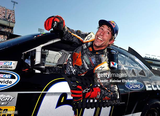 Travis Pastrana, driver of the Ford EcoBoost Ford, smiles as he gets out of his car during qualifying for the NASCAR Nationwide Series Virginia 529...