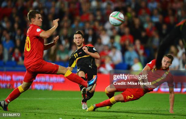 Dries Mertens shoots at goal despite the efforts of Aaron Ramsey and Chris Gunter of Wales during the FIFA 2014 World Cup Group A Qualifier between...