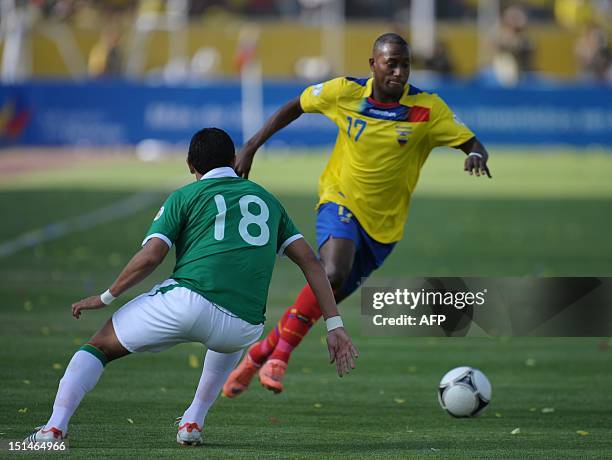 Ecuadorean player Jaimen Ayovi is marked by Bolivian player Jose Barba during their FIFA World Cup Brazil 2014 qualifying football match at the...