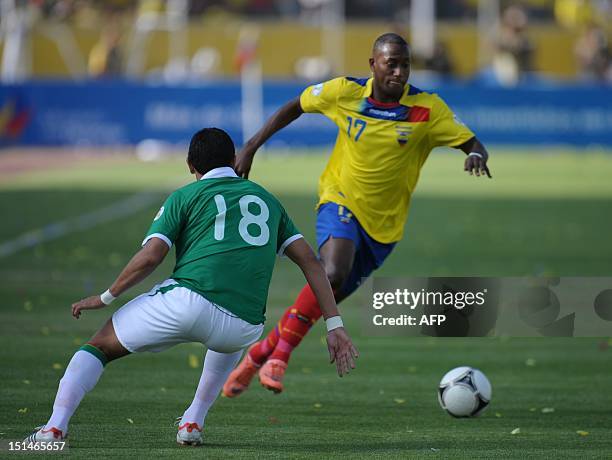 Ecuadorean player Jaimen Ayovi is marked by Bolivian player Jose Barba during their FIFA World Cup Brazil 2014 qualifying football match at the...