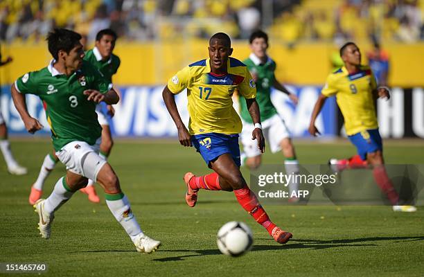 Ecuadorean player Jaimen Ayovi is marked by Bolivian player Luis Gutierrez during their FIFA World Cup Brazil 2014 qualifying football match at the...