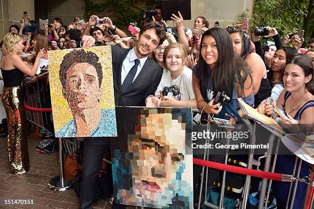 Actor James Franco poses with fans and portraits of himself as he attends the "Spring Breakers" premiere during the 2012 Toronto International Film...