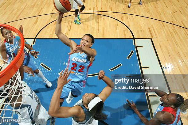 Armintie Price of the Atlanta Dream shoots the ball against Taj McWilliams-Franklin and Maya Moore of the Minnesota Lynx during the WNBA game on...