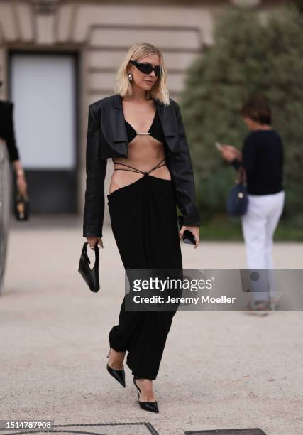 Lena Perminova seen outside Schiaparelli show wearing black bralette top, black maxi skirt, black cropped leather blazer and black heels during the...