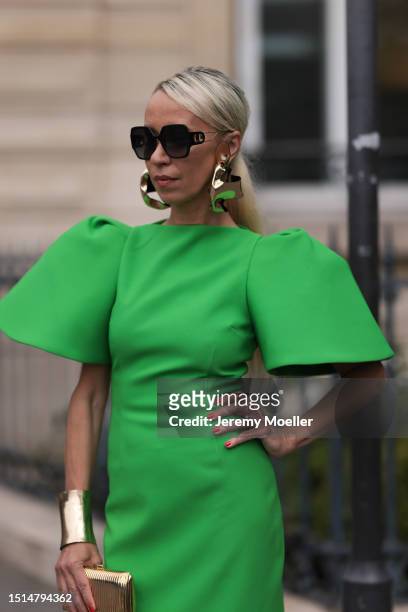 Denisa Palsha seen wearing Dior black squared sunglasses, gold statement earrings and gold statement bracelet, Solace London green midi dress with...