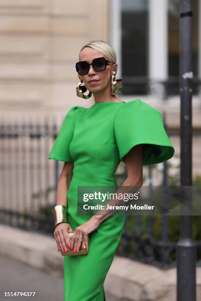 Denisa Palsha seen wearing Dior black squared sunglasses, gold statement earrings and gold statement bracelet, Solace London green midi dress with...