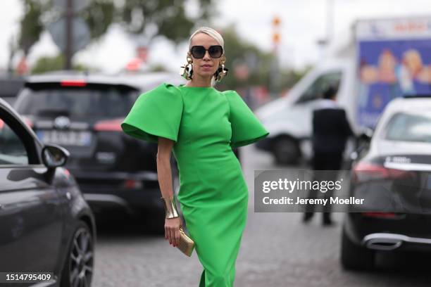 Denisa Palsha seen wearing Dior black squared sunglasses, gold statement earrings and gold statement bracelet, Solace London green midi dress with...