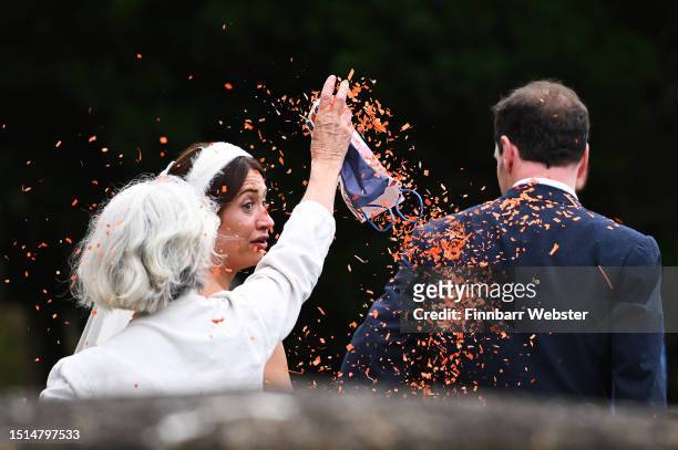 Woman throws confetti as former UK Chancellor George Osborne and Thea Rogers leave after their wedding at St Mary's Church, on July 8, 2023 in...