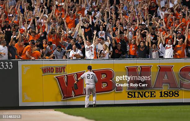 Left fielder Raul Ibanez of the New York Yankees looks on as fans celebrate a three RBI home run hit by Matt Wieters of the Baltimore Orioles during...