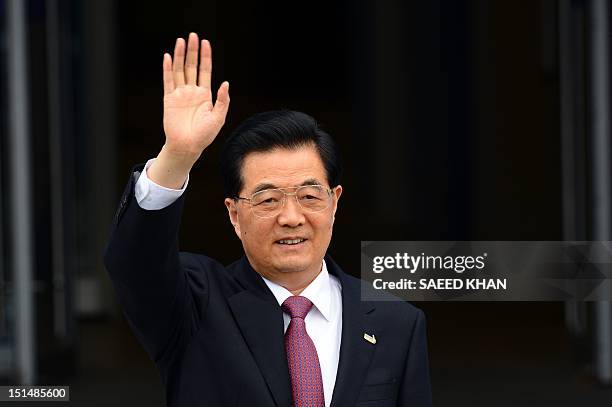 Chinese President Hu Jintao waves as he arrives to attend the Asia-Pacific Economic Cooperation summit in Russia's far eastern port city Vladivostok...