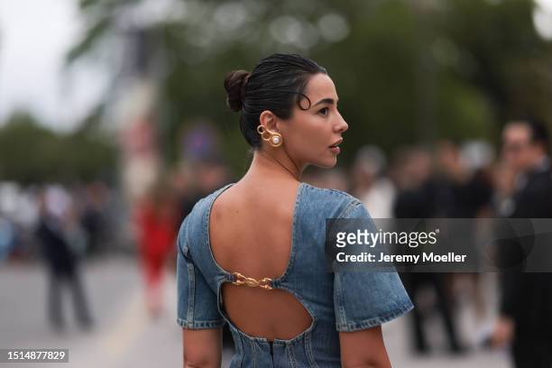 Guest seen outside Schiaparelli show wearing gold pearl Schiaparelli earrings, oversized denim Schiaparelli tshirt dress, Schiaparelli bag and...