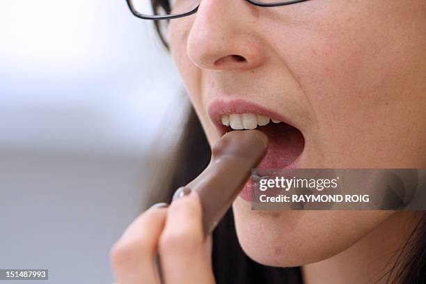 Woman puts in her mouth a coated marshmallow bear on August 23 at the headquarters of the French group CEMOI, specialized in the manufacturing of...