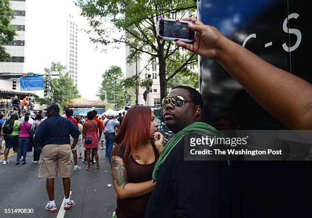 Kourtney Holman and Steven Hopkins hang out while Joy Holman of Concord, NC takes photos and videos of the scene in Charlotte on Sept 3 as the city...