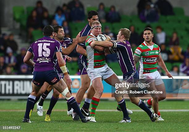 Michael Crocker of the Rabbitohs is challenged by his opponents during the Second NRL Qualifying Final match between the Melbourne Storm and the...