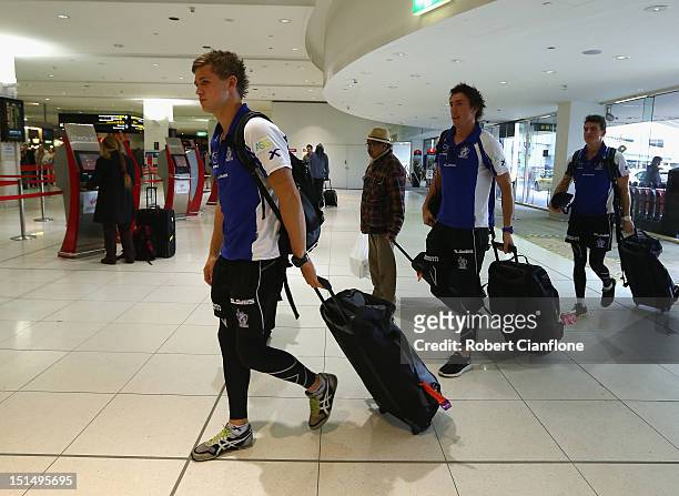 Kieran Harper, Samuel Wright and Aaron Mullett of the North Melbourne Kangaroos arrive at Melbourne Airport on September 7, 2012 in Melbourne,...