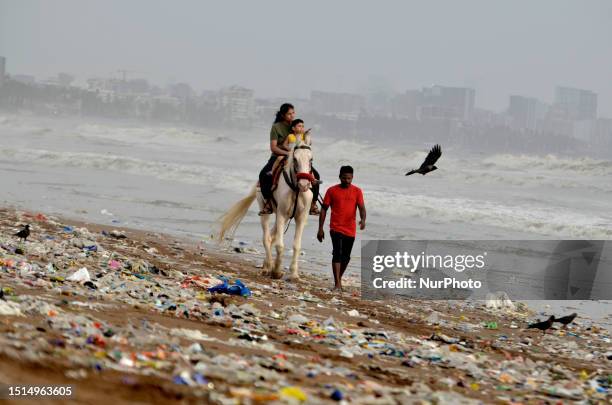 People enjoys evening horse ride near a polluted sea beach after the high tide during monsoon in Mumbai, India, 08 July, 2023.