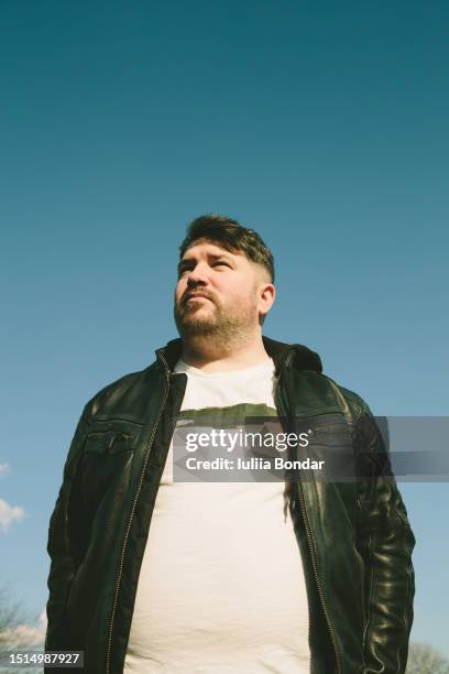 young man posing over the blue sky - man staring into distance stock pictures, royalty-free photos & images