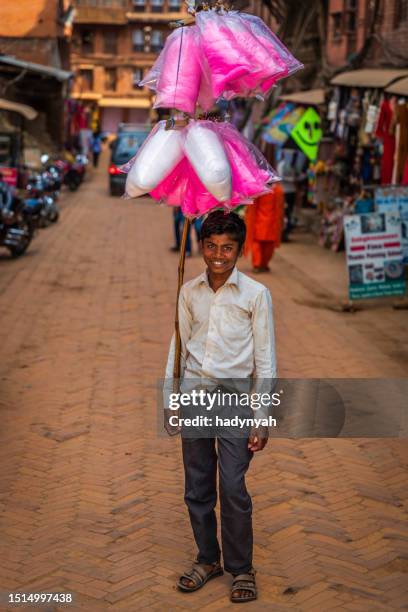 young nepali boy selling a cotton candy in bhaktapur, nepal - trabalho infantil imagens e fotografias de stock