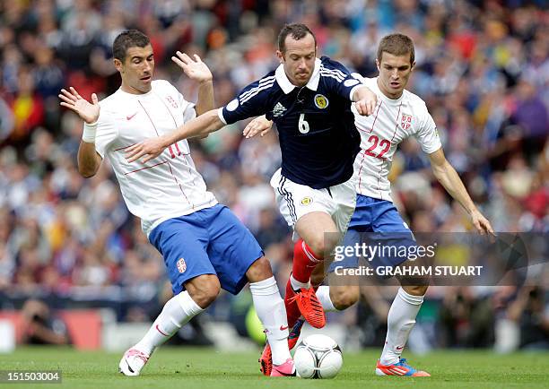 Serbia's Aleksandar Kolarov and Darko Lazovic vies with Scotland's Charlie Adam in a FIFA 2014 World Cup, group A, qualifying football match at...