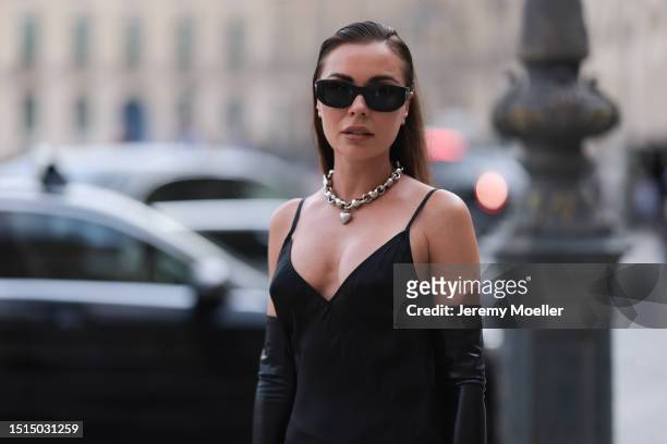 Fashion Week Guest seen wearing a black long dress, black leather handgloves, black Balenciaga shades, silver necklace statement chain, a black mini...
