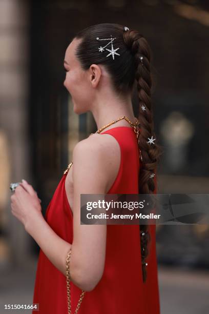 Fashion Week Guest seen wearing a red long Schiaparelli dress with golden details and statements, a golden handbag with a chain, silver hair clips...