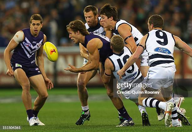 Matt De Boer of the Dockers handballs whilst being tackled by Taylor Hunt of the Cats during the Second AFL Elimination Final match between the...