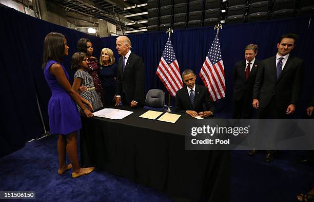 Malia Obama, Sasha Obama, First Lady Michelle Obama and Dr. Jill Biden look on as Vice President Joe Biden and U.S. President Barack Obama sign the...