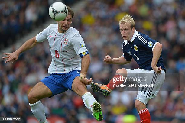 Steven Naismith of Scotland tackles Branislav Ivanovic of Serbia during the FIFA 2014 World Cup Qualifier at Hampden Park between Scotland and Serbia...