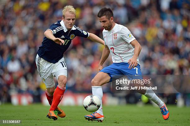 Steven Naismith of Scotland tackles Zoran Tosic of Serbia during the FIFA 2014 World Cup Qualifier at Hampden Park between Scotland and Serbia on...