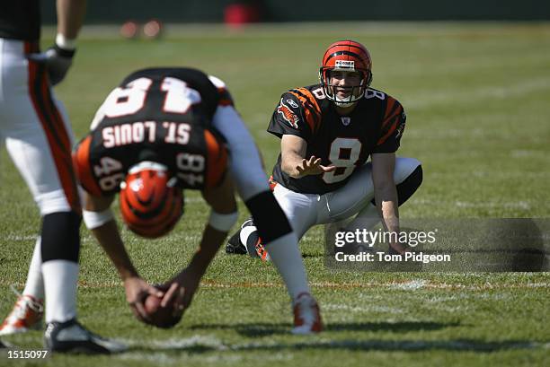 Kick holder Nick Harris of the Cincinnati Bengals looks to receive the football from teammate long snapper Brad St. Louis during warms ups before the...