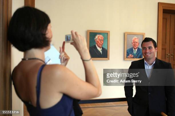 Visitor photographs another in front of paintings of former German presidents Theodor Heuss and Heinrick Luebke at the Citizens Fest at Bellevue...