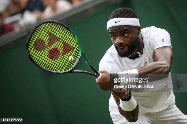 Player Frances Tiafoe returns the ball to Bulgaria's Grigor Dimitrov during their men's singles tennis match on the sixth day of the 2023 Wimbledon...