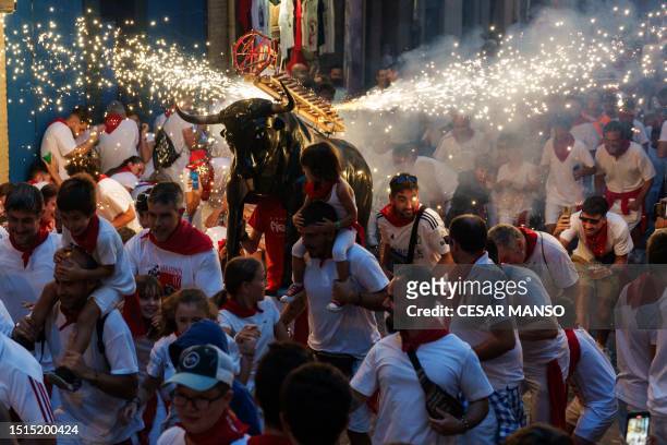 Man wearing a costume of "Toro de Fuego" chases revellers during the San Fermin Festival in Pamplona, northern Spain, on July 8, 2023.