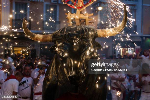 Man wearing a costume of "Toro de Fuego" chases revellers during the San Fermin Festival in Pamplona, northern Spain, on July 8, 2023.