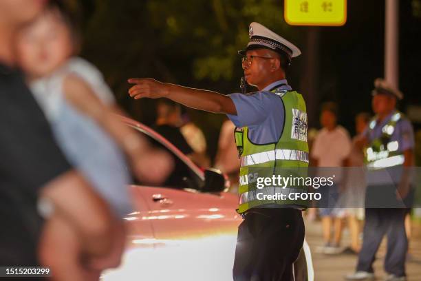 Police officers are on duty at the fireworks show area for the opening of the International Sand Sculpture Festival in Zhoushan city, Zhejiang...