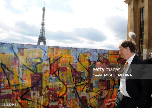 Microsoft founder and philanthropist Bill Gates looks at a painting of two artists Dag and Russian Artof Popof on April 4, 2011 at the Trocadero in...