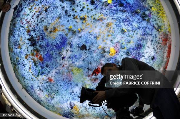 Cameraman operates beneath a ceiling painted by Spanish artist Miquel Barcelo on March 22, 2010 at the UN office in Geneva, during a Human Rights...