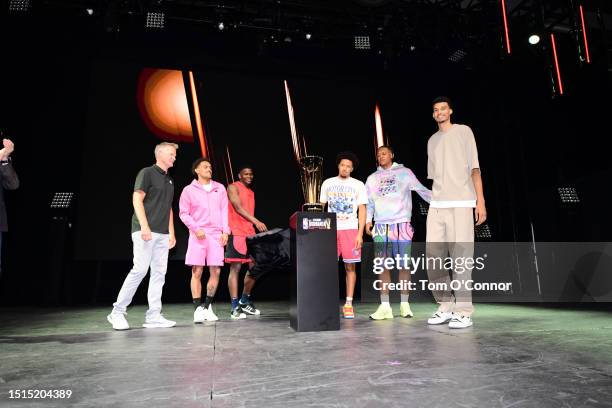 Steve Kerr, Trae Young, Anthony Edwards, Cade Cunningham, Paolo Ranchero and Victor Wembanyama unveils the Championship Trophy for the In Season...