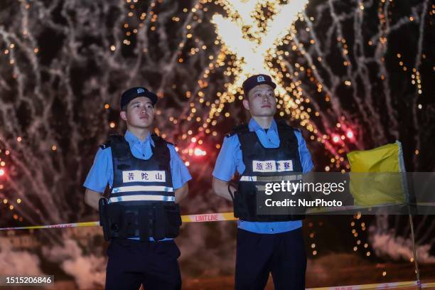 Police officers are on duty at the fireworks show area for the opening of the International Sand Sculpture Festival in Zhoushan city, Zhejiang...