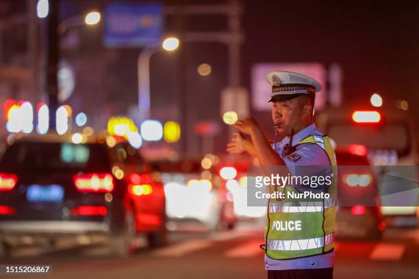 Police officers are on duty at the fireworks show area for the opening of the International Sand Sculpture Festival in Zhoushan city, Zhejiang...